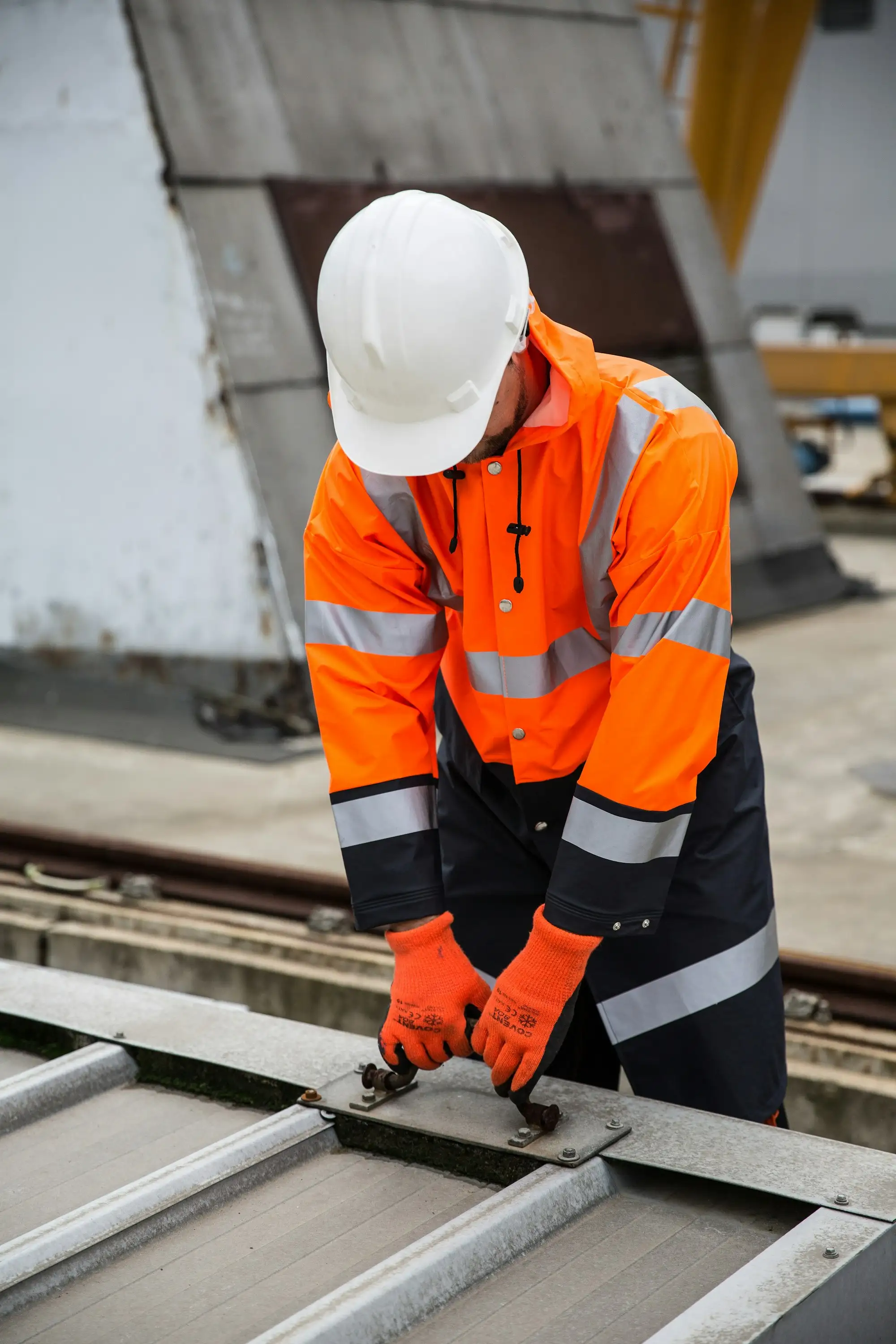 Australian tradie in orange hi vis workwear on a job site
