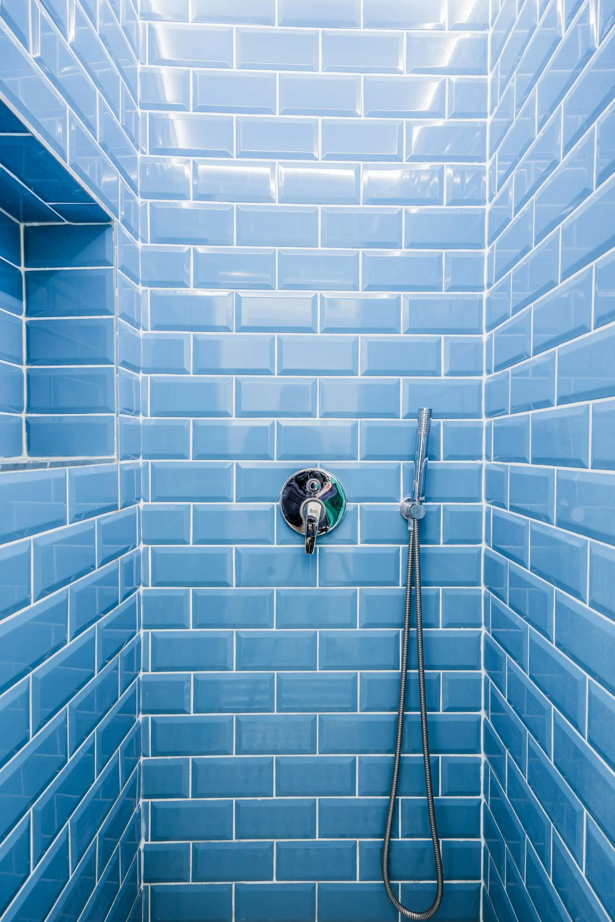 Tiler laying wall tiles in a new Australian bathroom